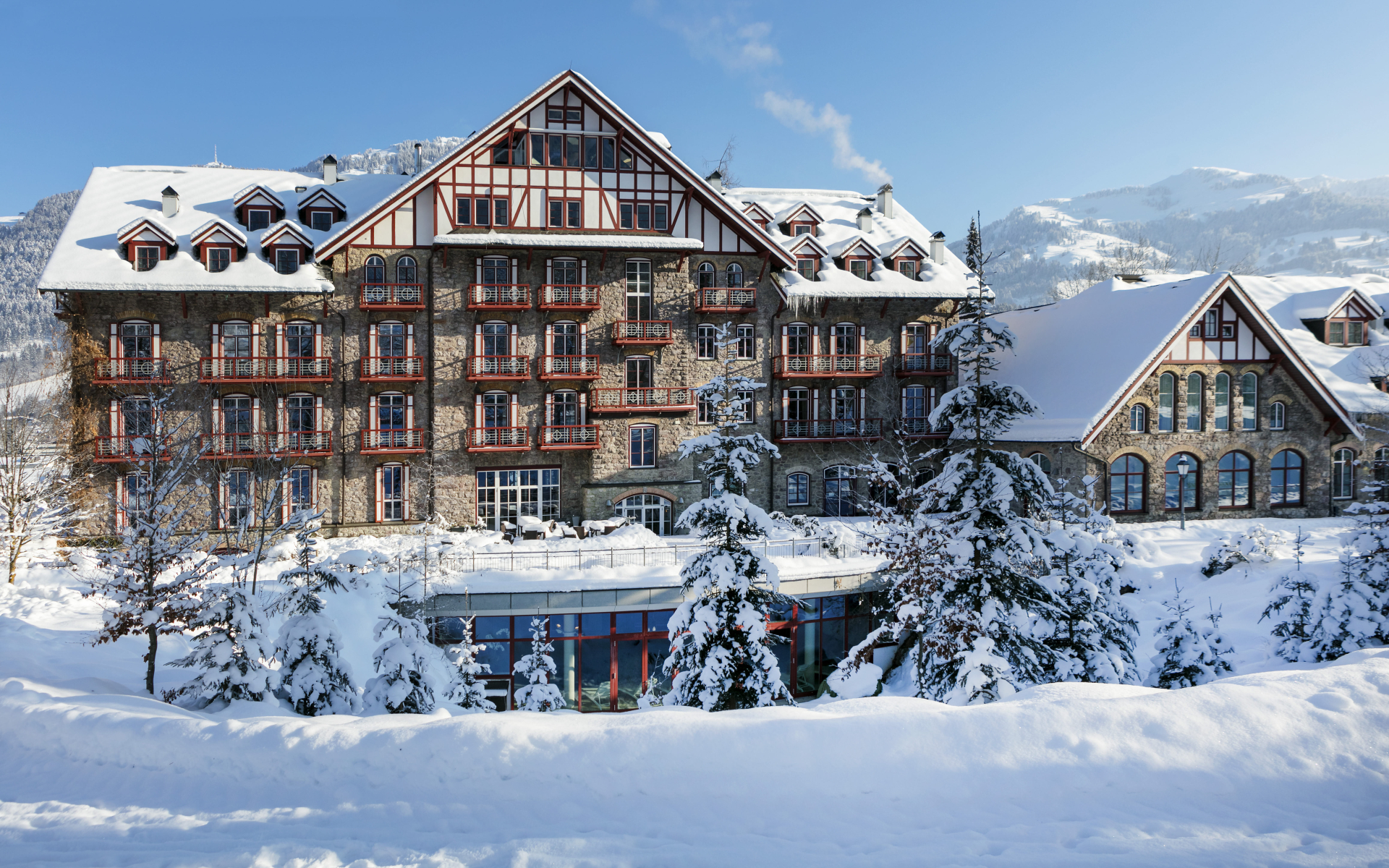 Snow-covered Grand Hotel with mountains in the background